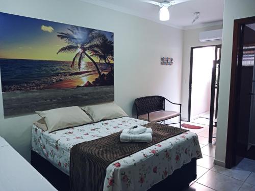 1 dormitorio con 1 cama con una pintura en la pared en Refúgio BEM-TE-VI en Guarujá