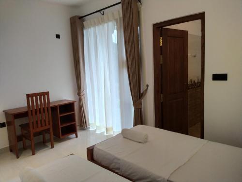 a bedroom with two beds and a chair and a mirror at Kandy Lotus Chalet in Kandy