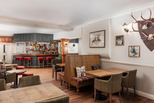un restaurant avec des tables et des chaises ainsi qu'un bar dans l'établissement Tulloch Castle Hotel ‘A Bespoke Hotel’, à Dingwall