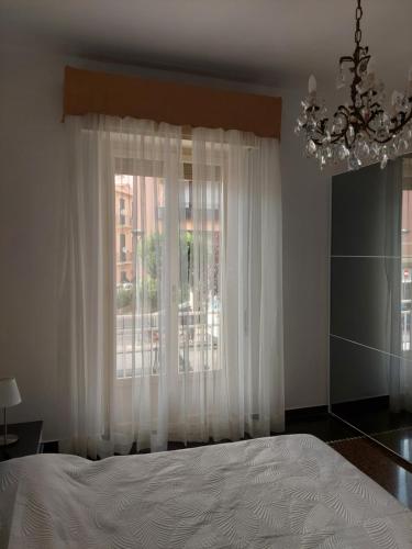 a bedroom with a bed and a window with a chandelier at Casa delle fiabe in Sestri Levante