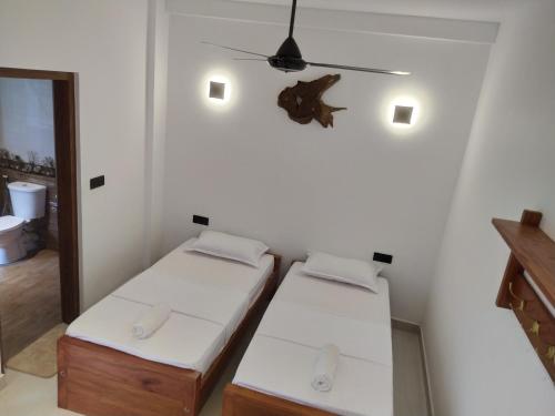 two beds in a small room with a ceiling at Kandy Lotus Chalet in Kandy