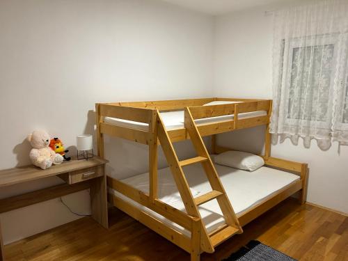 a bunk bed with a ladder and a teddy bear at Apartman Milla in Ljubuški