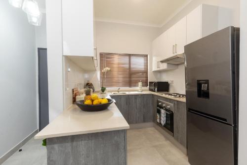 a kitchen with a bowl of fruit on a counter at One More Night Apartment E202 in Gaborone