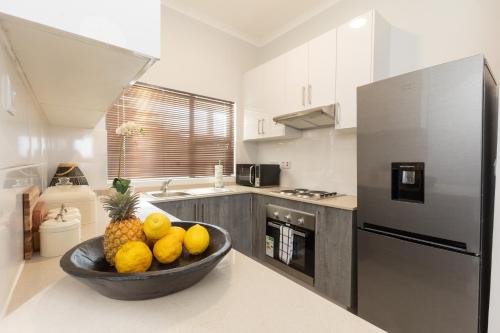 a kitchen with a bowl of fruit on the counter at One More Night Apartment E202 in Gaborone