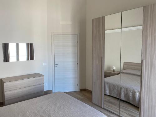 ein Schlafzimmer mit einem Bett und einem großen Spiegel in der Unterkunft Paola Confort House in Avola