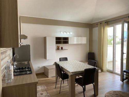 eine Küche und ein Esszimmer mit einem Tisch und Stühlen in der Unterkunft Paola Confort House in Avola