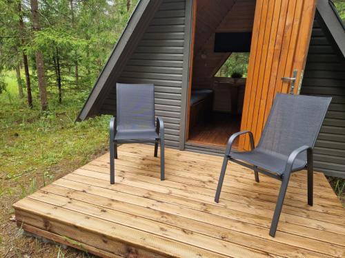 two chairs on a deck in front of a cabin at Rõmeda kämping in Rõmeda