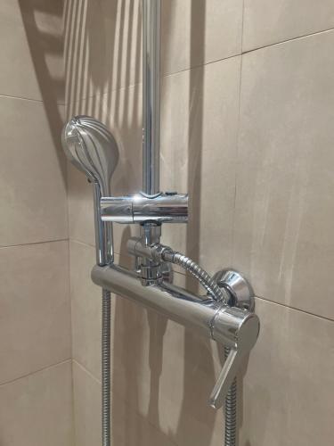a shower stall with a chrome shower head in a bathroom at Apartment Castle Square z widokiem na Plac Zamkowy i Zamek Królewski in Warsaw