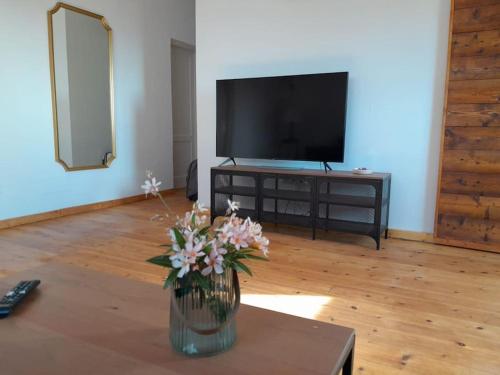 a living room with a vase of flowers on a table at Casagrande Sunset II - Fuerteventura - Costa Calma in Pájara