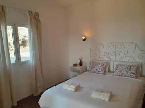 a white bedroom with a large white bed with two pillows at Casagrande Sunset II - Fuerteventura - Costa Calma in Pájara