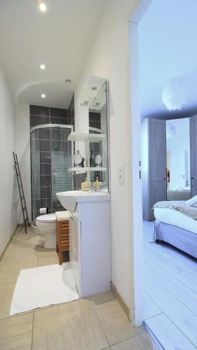 - une salle de bains blanche pourvue d'un lavabo et d'un lit dans l'établissement Le Tamaris, Garage privé hauteur limitée, Calme, Confort, à Troyes