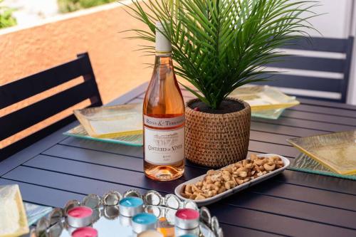 - une bouteille de vin assise sur une table avec une plante dans l'établissement Amazing apartment 5P with A/C- Eiffel Tower's view, à Châtillon