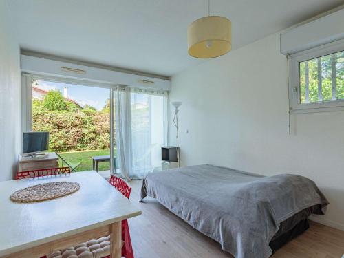 1 dormitorio con cama, mesa y ventana en Studio Anglet, 1 pièce, 2 personnes - FR-1-3-437, en Anglet