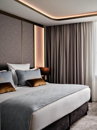 a bedroom with a large white bed with curtains at The Crown Krakow Center - Handwritten Collection ACCOR in Kraków