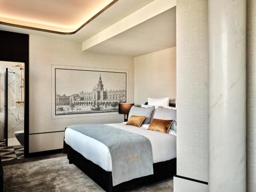 a bedroom with a large bed and a painting on the wall at The Crown Krakow Center - Handwritten Collection ACCOR in Kraków