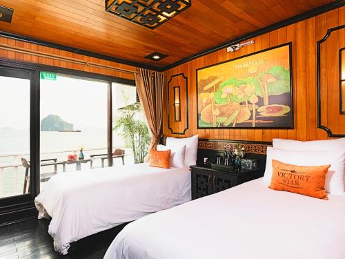 Duas camas num quarto com vista para o oceano em Victory Boutique Cruise em Ha Long