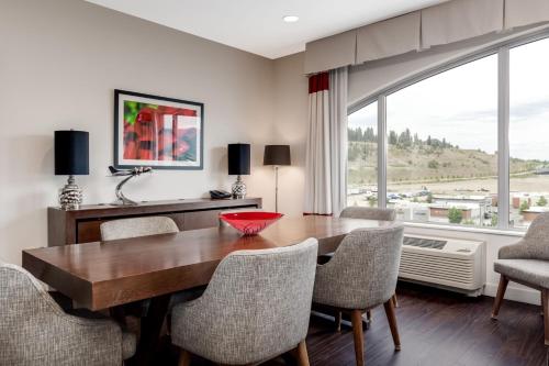 a dining room with a table and chairs and a large window at Four Points by Sheraton Kelowna Airport in Kelowna