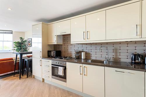 een keuken met witte kasten en een fornuis met oven bij Crystal Palace Residence II in Londen