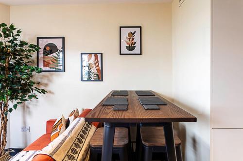 ein Esszimmer mit einem Holztisch und einem Sofa in der Unterkunft Crystal Palace Residence II in London