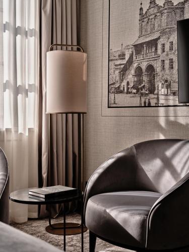 a living room with a chair and a lamp at The Crown Krakow Center - Handwritten Collection ACCOR in Kraków
