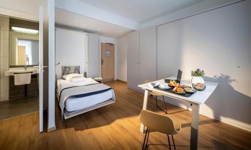 a bedroom with a bed and a desk with a computer at Ciarus in Strasbourg