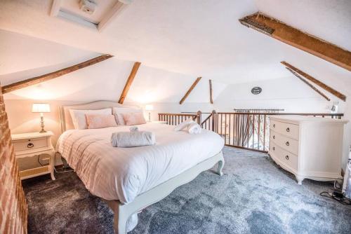 a bedroom with a large white bed and a dresser at The Black House, Wangford in Beccles