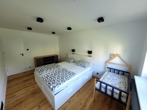 two beds in a room with wooden floors at Apartament Wrzos in Cisna