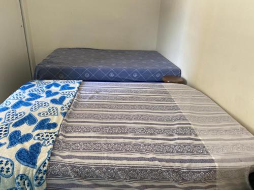 ein kleines Schlafzimmer mit einem Bett mit blauer Matratze in der Unterkunft Enseada guaruja in Guarujá