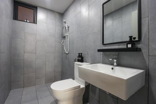 uma casa de banho com um WC branco e um lavatório. em Lovely 3-bedroom w pool 7 pax - Jalan Cheras em Kuala Lumpur