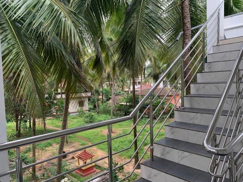 a staircase leading up to a house with palm trees at Panchavati Homestay in Malpe