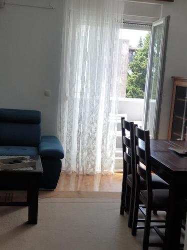 a living room with a table and a blue couch at An apartment 65m2-Ljubuški in Ljubuški