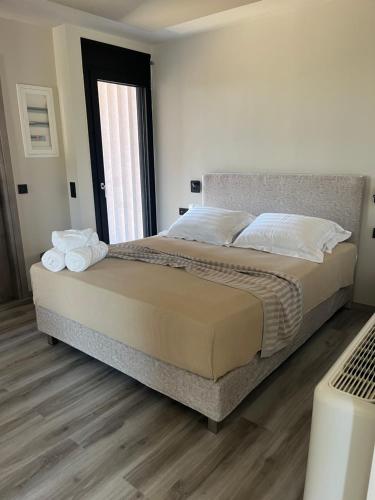 a bedroom with a bed with white pillows and a window at Grand Kourouta in Kourouta
