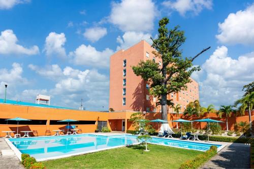 a hotel with a pool in front of a building at City Express by Marriott Villahermosa in Villahermosa
