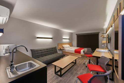 a hotel room with a couch and a bed at City Express Plus by Marriott Ciudad de México Periférico Sur Tlalpan in Mexico City
