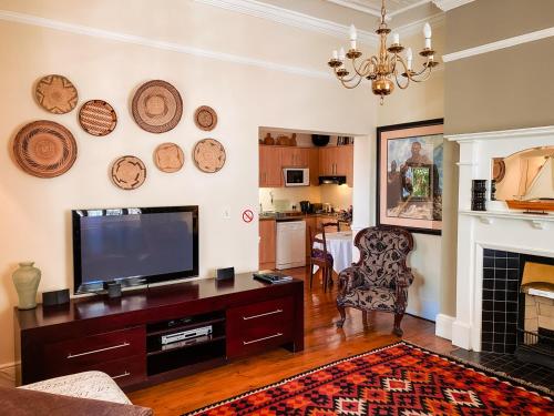 a living room with a television and a fireplace at 5 Camp Street Guesthouse & Self-catering in Cape Town