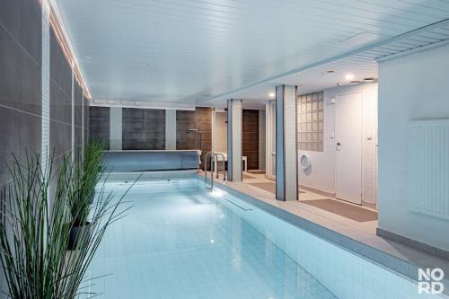 a large swimming pool in a large room with at Westend Luxury Spa House in Espoo