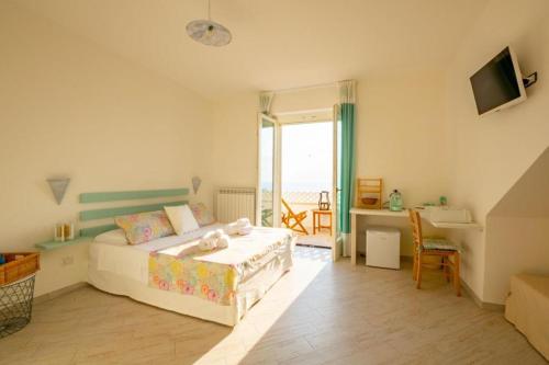 1 dormitorio con cama, escritorio y ventana en FinisTerrae Rooms and Suites, en Gagliano del Capo