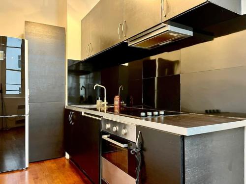 eine Küche mit einer Spüle und einem Herd Top-Backofen in der Unterkunft Exclusive Suite Parisian Palace in Paris