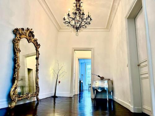 Zimmer mit einem Spiegel und einem Kronleuchter in der Unterkunft Exclusive Suite Parisian Palace in Paris