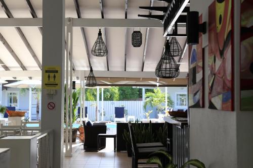 un couloir avec des chaises et des lampes suspendues dans un bâtiment dans l'établissement Hotel La Roussette, à Anse aux Pins