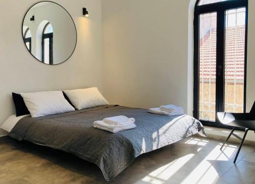 una camera da letto con un letto con uno specchio sul muro di Lovely New Private Duplex in Prime City Center location a Gerusalemme