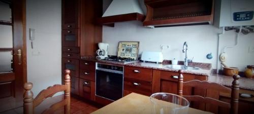 a kitchen with a table and a stove top oven at As pitas in Tapia de Casariego