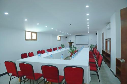 a conference room with a long table and red chairs at The BD Hotel in Thimphu