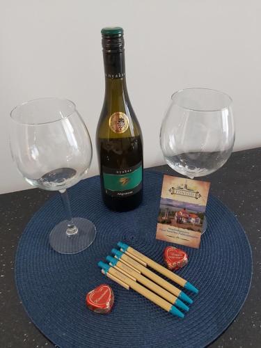 a blue plate with a bottle of wine and two glasses at Edison Villa 106 in Fonyód