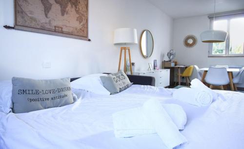 a white bed with white sheets and pillows on it at Le Tamaris, Garage privé hauteur limitée, Calme, Confort in Troyes
