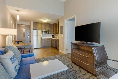 a living room with a blue couch and a flat screen tv at Residence Inn Providence Downtown in Providence
