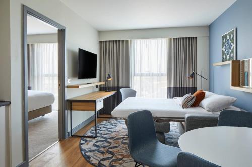 a hotel room with a bed and a desk at Residence Inn by Marriott Slough in Slough