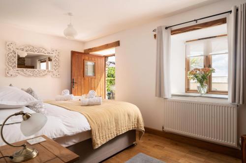 Postel nebo postele na pokoji v ubytování Corn Barn at East Trenean Farm -Luxury Cornish Barn Conversion sleeping 8 with hot tub, private garden, rural views and EV facilities