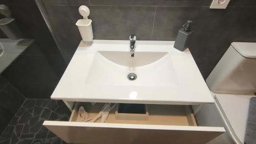 Small and Cozy Rooms - G10 في فالنسيا: وجود مغسلة بيضاء في الحمام بجانب المرحاض