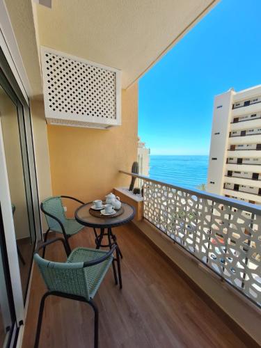 uma varanda com uma mesa e cadeiras e o oceano em SEAFRONT APARTMENT em Marbella